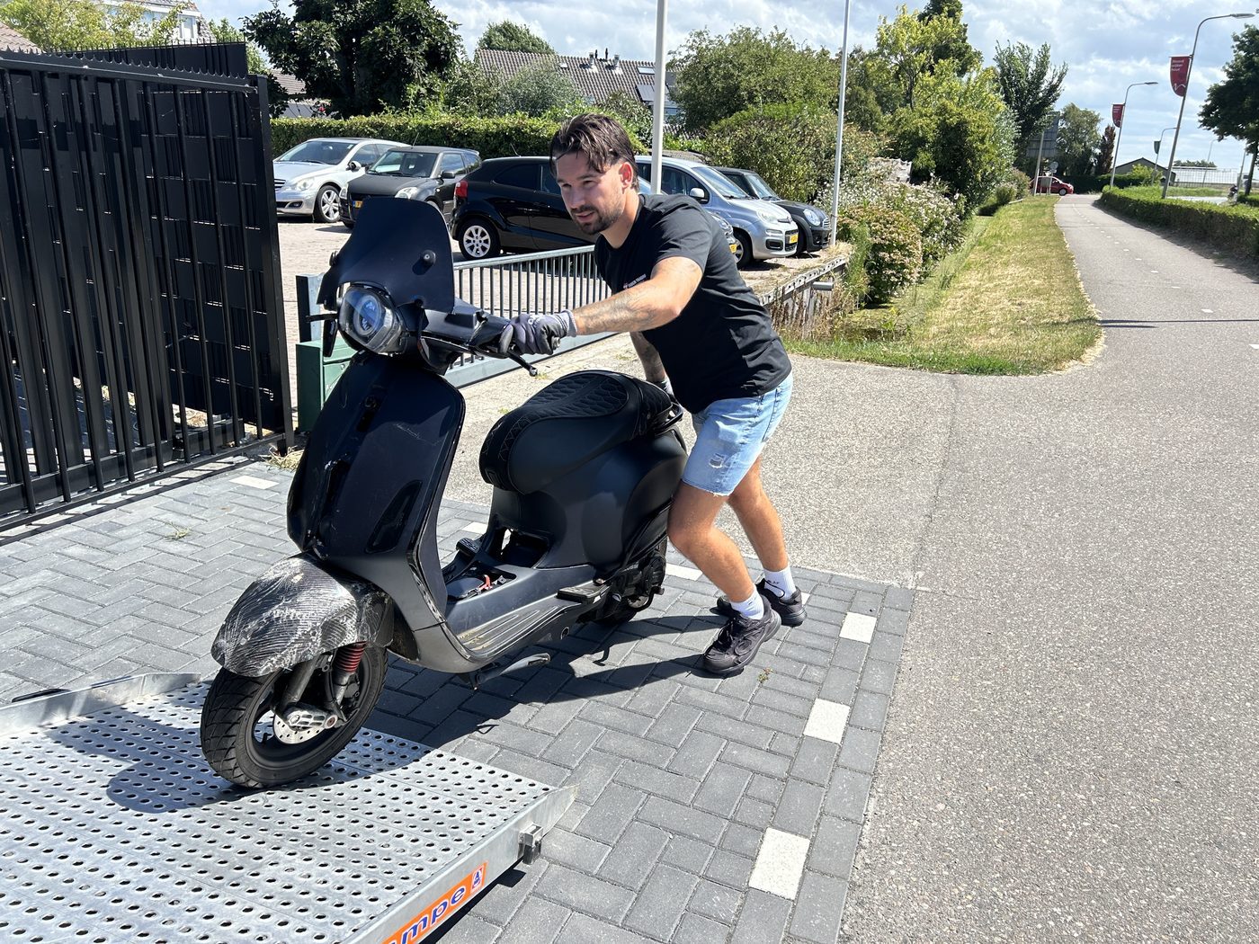Een scooter wordt via de oprijplaat de bus in gereden